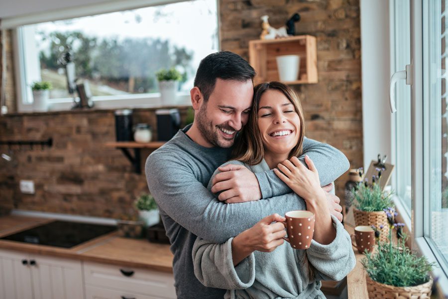 Annuities - Couple Embracing in the Morning Sunlight at Home